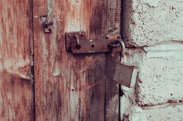 Old shabby door with rusty metal padlock unlocked