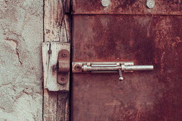 Old shabby rusty door with latch unlocked