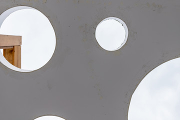 unusual design removed from the bottom. through the round-shaped holes, you can see the sky completely covered in clouds and see the contrasting part of the same structure. background