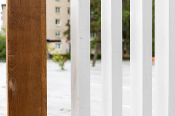 Fototapeta premium background. wooden vertical structure made of white and wood-colored beams. clear shapes in contrast to the bokeh of the backside