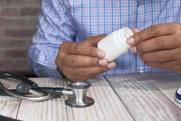 young man holding white pill container, 