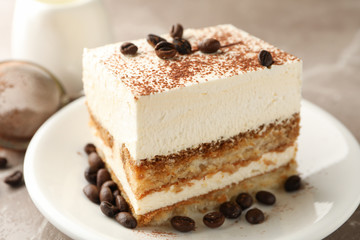 Composition with plate of tiramisu on light brown background. Tasty dessert
