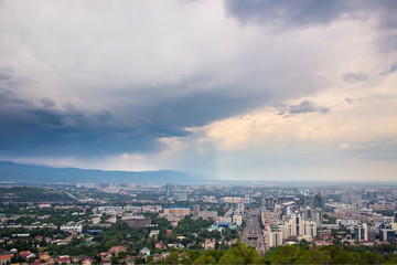 Fototapeta na wymiar City summer landscape. Panorama of the summer city. Rainy weather. Almaty, Kazakhstan