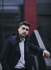 Handsome young man in suit and coat posing in city © jozzeppe777