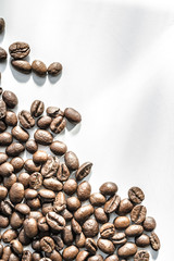 scattered coffee beans on a white background. The concept of a background image.