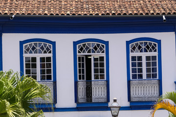 Close up front view of an historical building with three windows in white and blue, Diamantina, Minas Gerais, Brazil