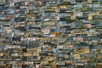 Decorative wall made of processed stones. Different types of decorative stone
