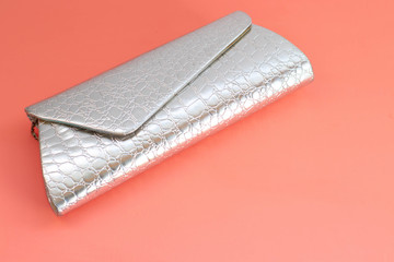Silver women clutch for evening outings. Clutch bag on a pink background, place for text, copy space