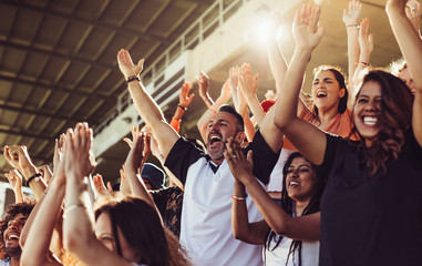Fototapeta Crowd of sports fans cheering during a match in stadium obraz