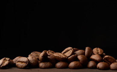 roasted coffee beans arabica on a wooden table, black background