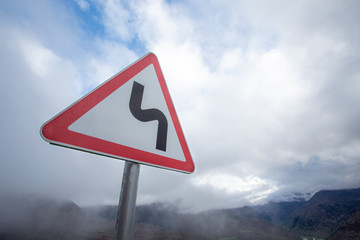 Warning road sign mountain serpentine