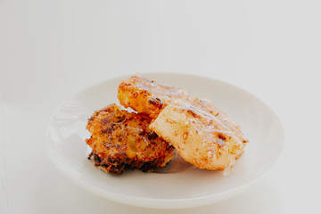 three fried cottage cheese pancakes on a white plate. Cheesecakes with cottage cheese and syrup