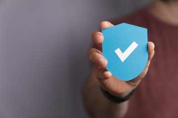 Man holding a protection shield with a checkmark