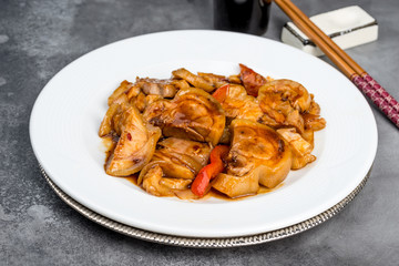 Fried shank in soy sauce served in a round white plate