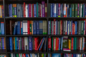 Many different books on the shelves. Close-up. Blurred.