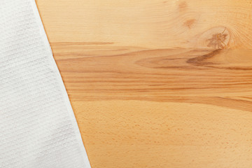 Top view on a wooden table with a linen kitchen towel or textile napkin.