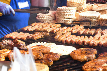 Chef grilling meat during cookout picnic or food event. Meat mix variety, Labour Day, 1 Mai