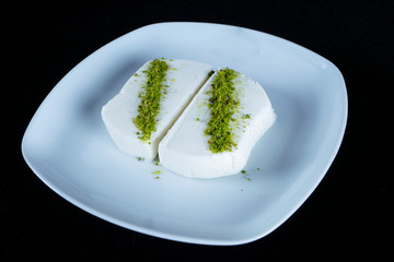 ice cream, Turkish ice cream Maras with pistachios, close-up. Slices of creamy ice-cream on the white plate.  two ice cream scoops on white plate close-up