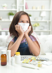 Portrait of little girl wearing facial mask with pills