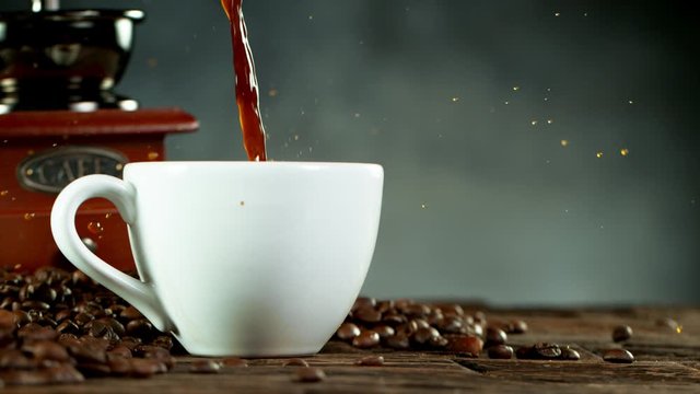 Super slow motion of pouring coffee into cup with copy space. Filmed on high speed cinema camera, 1000fps