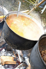 Very large cauldron cooking food during campfire. Cooking in a pot on the fire. Camping concept