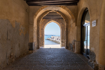Fototapeta na wymiar View to the old harbour and beach from Porta Pescara fishermen's gate on a sunny day in Cefalu, Sicily, Southern Italy.