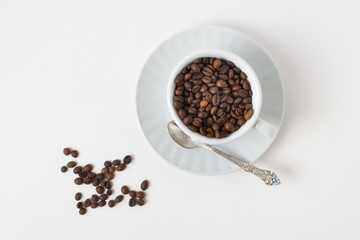 Cup оf coffee , white ceramic cup with roasted coffee beans on a white background. Isolate. Space for text. Top view