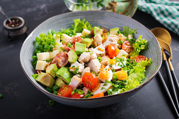 Healthy cobb salad with chicken, avocado, bacon, tomato, cheese and eggs. American food.