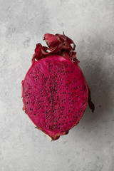 Сut of fresh dragon fruit on concrete background close up.