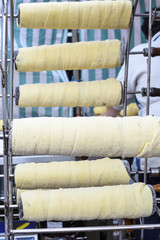 Kurtos kalacs or chimney cakes, preparing on charcoal grill, street food traditional Hungarian