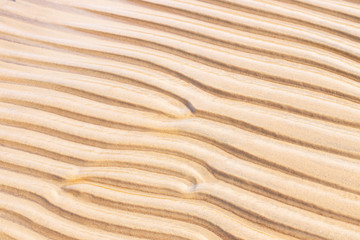 Fototapeta na wymiar Sand texture wave pattern on the beach.