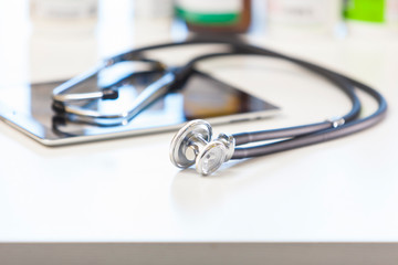 Tablet computer and stethoscope on the table. Online medicine.