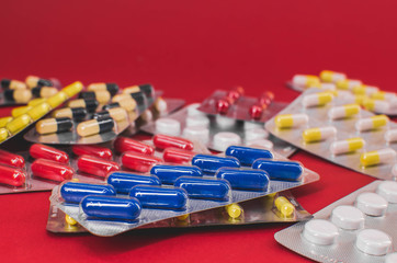 pile of multicolored tablets on a red background