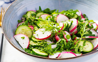 Vegetarian vegetable salad of radish, cucumbers, arugula and green onions. Healthy  vegan food.