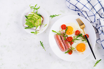 English breakfast - fried eggs, sausages, tomatoes and arugula. American food. Top view, overhead, copy space