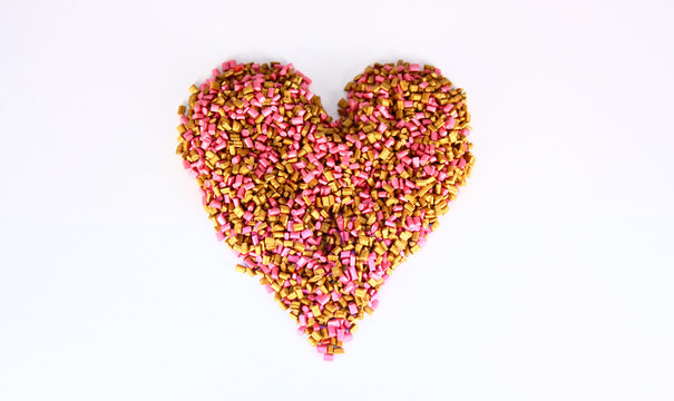Gold and pink Colored pigment granules were shot on white background.