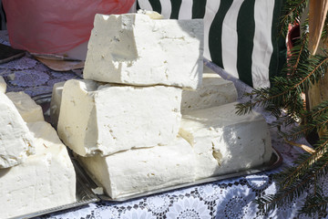 A variety of wheels of cheese seasoned with herbs for sale at the deli counter in the supermarket.
