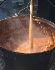 Very large cauldron cooking food during campfire. Cooking in a pot on the fire. Camping concept