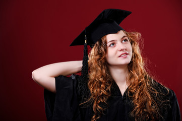 Female student in academic gown in red background