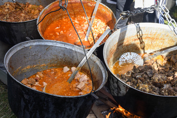 Very large cauldron cooking food during campfire. Cooking in a pot on the fire. Camping concept