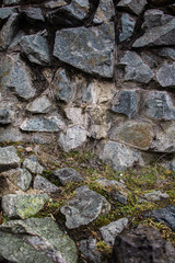 Obraz premium A lot of stones in the background and foreground, various shapes, sizes and shades. Green grass in the center