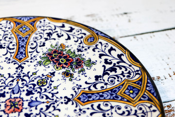 Beautiful vintage ornamental plate on wooden table close up-