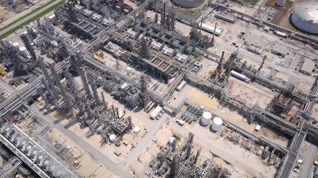 Aerial Parallax Shot of A Crude Oil Refinery Complex in A Houston Industrial Aeri. Drone Orbiting View of a Chemical Factory with Complicated Networks of Pipelines, Huge Chimneys and Massive Storage