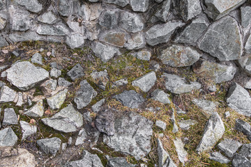 Green and yellow grass among stones of different shapes