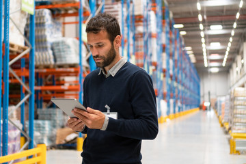 Manager holding digital tablet in warehouse	
