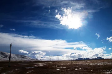 Fototapete Shishapangma Plateau, Hochspannungsmast, blauer Himmel und weiße Wolken, Eissee und ferner Shishapangma-Gipfel