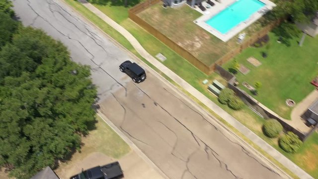Tracking a car down a residential street, Bryan, Texas, USA