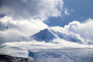 Plateau, tour de transmission haute tension, ciel bleu et nuages blancs, lac de glace et lointain pic Shishapangma