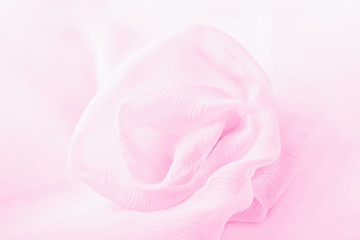 Fototapeta na wymiar Silk pink flower rose on a pale pink background, copy space