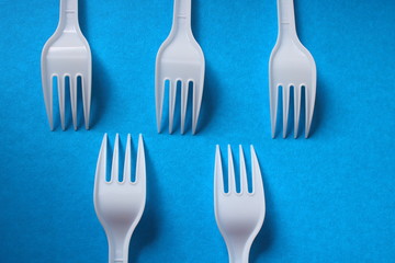 plastic forks lie on a blue background like chess